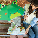Two people sitting on a bench, one holding a green frog-shaped umbrella and the other reading a book.