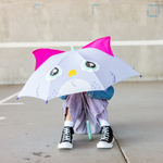 Person holding an owl-themed umbrella in an outdoor setting