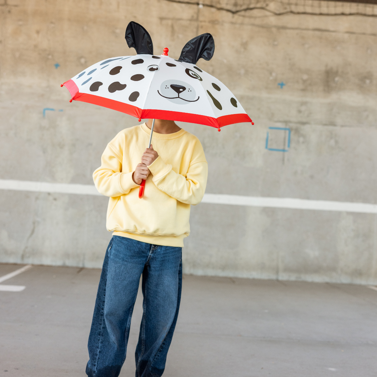 Person holding a dog-themed umbrella in an outdoor setting